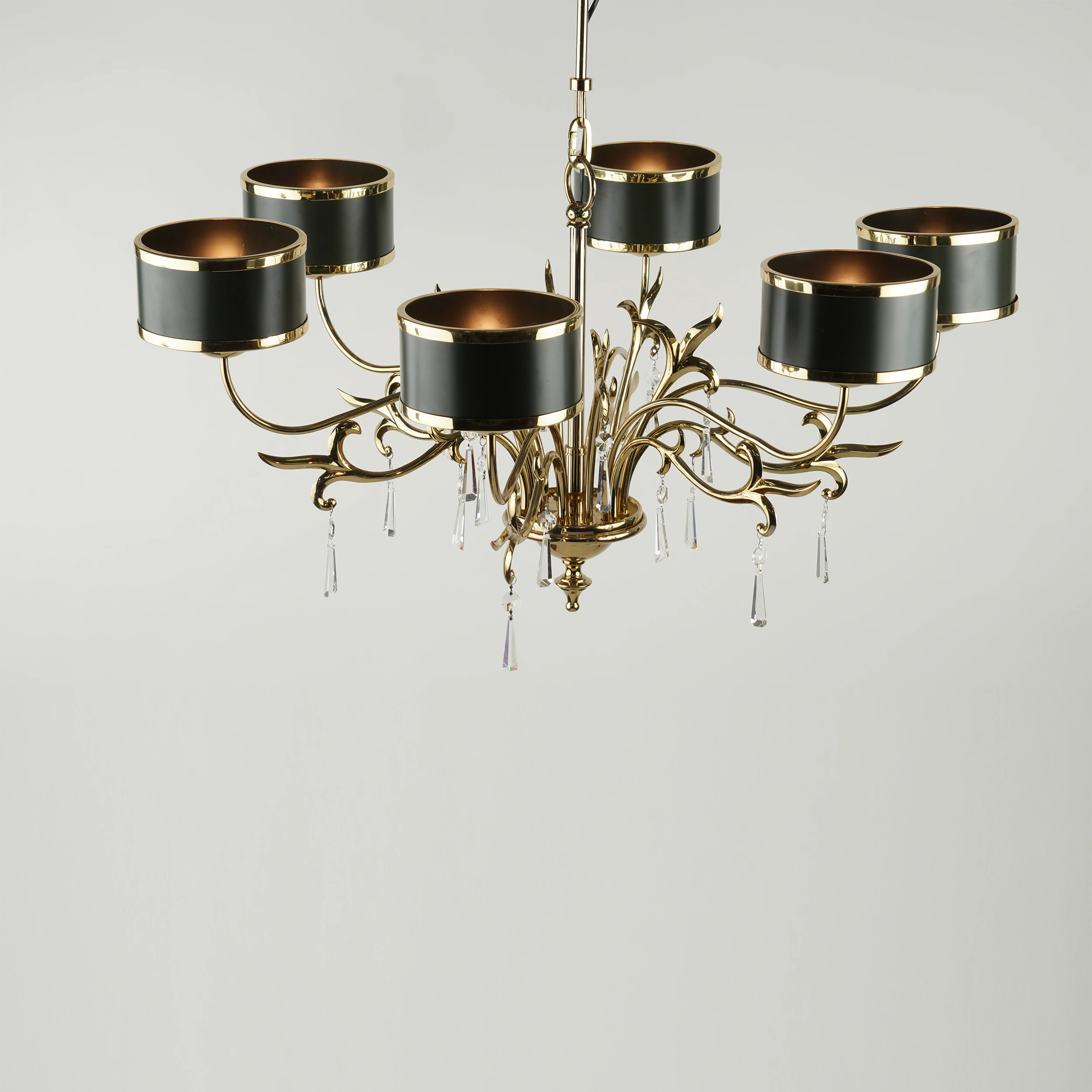 The VICTORIA CHANDELIER features six curved gold arms, each with a black and gold cylindrical shade and crystal pendants, all set against a plain white background. The VICTORIA CHANDELIER features six curved gold arms, each with a black and gold cylindrical shade and crystal pendants, all set against a plain white background.