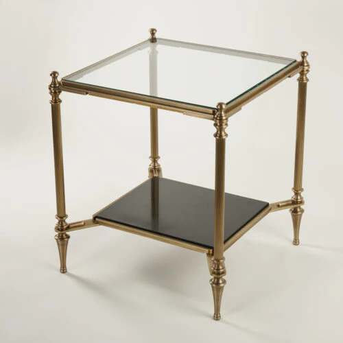 The MEDFORD END TABLE features a square glass top, gold metal frame, four tapered legs, and a lower black shelf, displayed against a plain white background.